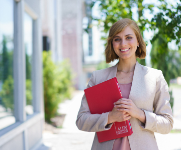 Female insurance agent with folder in front of office